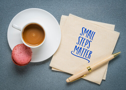 Small Steps Matter &ndash; inspirational handwritten note on a napkin with coffee and pen, reminding that consistent daily actions lead to meaningful success.