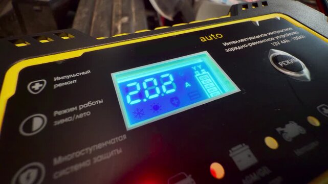 A smart battery charger reassuringly displays a clear status. This reliable tool provides a safe feeling of relief inside a dim garage workshop.