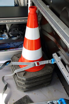 Warnkegel ist in einem Fahrzeug mit einem Spanngurt gesichert