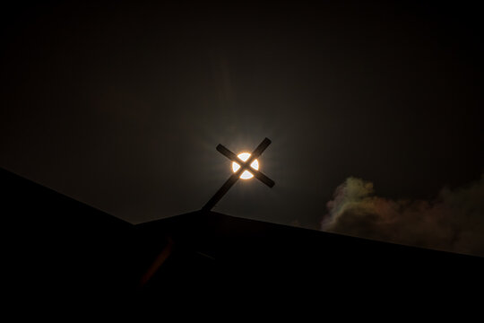 View of the broken cross atop San Jose Catholic Church silhouetted against the sun in San Jose, Tinian, Northern Mariana Islands.