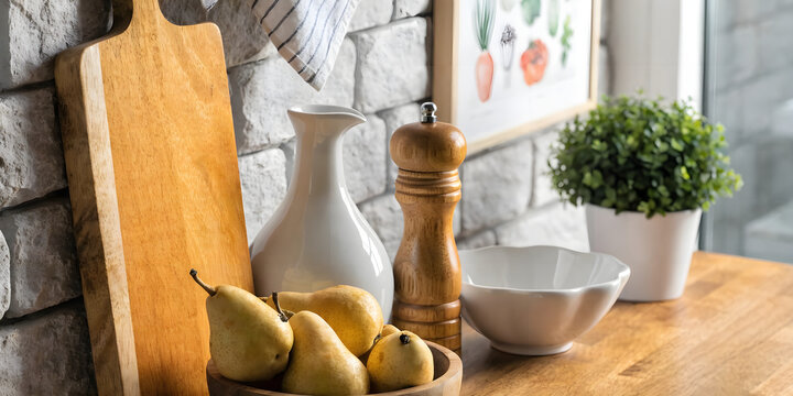 Kitchen counter with wooden cutting board, pears, pitcher and plant