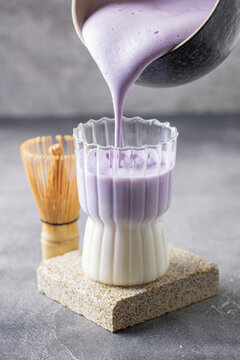 Ube latte in glass. Healthy vegan drink. Viral trendy asian beverage