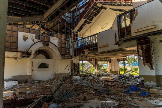 View of the damaged interior of San Jose Catholic Church with exposed structural framing, debris scattered across the floor, and ruined walls in San Jose, Tinian, Northern Mariana Islands.
