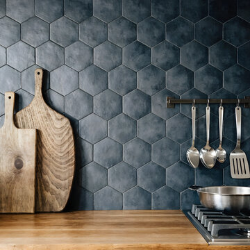 Modern kitchen interior with dark blue hexagonal tiles and wooden counter