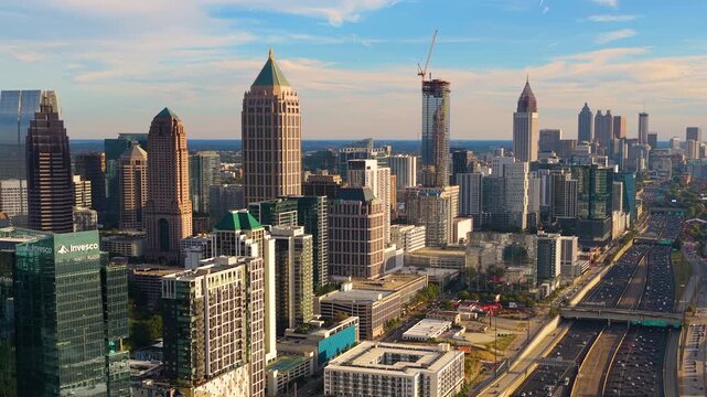 Urban Atlanta cityscape with modern skyscraper buildings and driving traffic on city highways. American transportation system and metropolitan mobility.