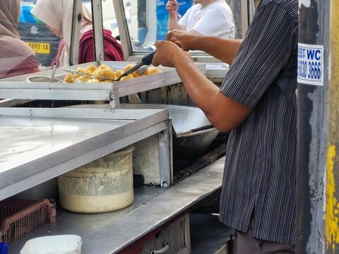 Indonesian Street Food Vendor Preparing Fried Snacks on Food Cart