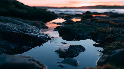 Obraz premium A peaceful close up view of tide pools reflecting vibrant sunset colors at dusk creating a serene and calm ambiance