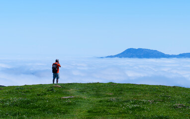 Obraz premium Man photographs sea of clouds in Picos de Europa