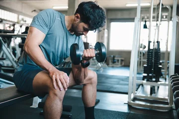 Man dumbbell gym exercise fitness bench muscle workout man lifting dumbbell on bench inside modern gym with focused expression and athletic training routine © chokniti