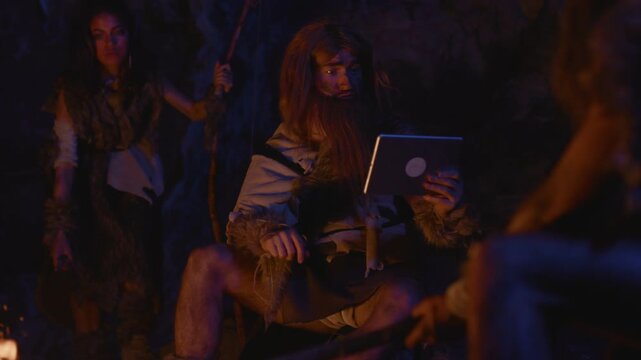 A whimsical scene showcasing a caveman interacting with a tablet in a dark and ancient cave