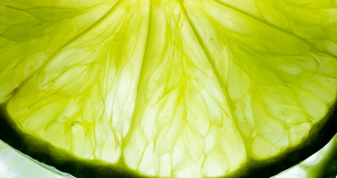 Macro Close-up of Fresh Lime Slice Texture,A vibrant, high-resolution macro shot highlighting the intricate, translucent cell structure and juicy pulp details of a fresh lime slice, illuminated from.