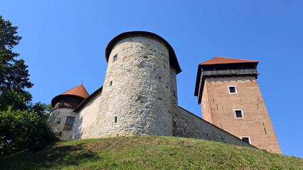 Obraz premium Medieval stone fortress with a large round bastion and a tall square brick watchtower