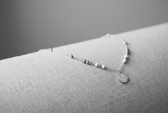 Delicate Silver Charm Bracelet on Soft Linen Fabric