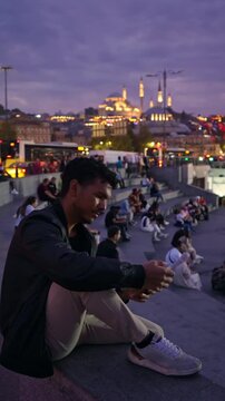 Solo Traveler Sitting Above Busy Istanbul Waterfront at Dusk