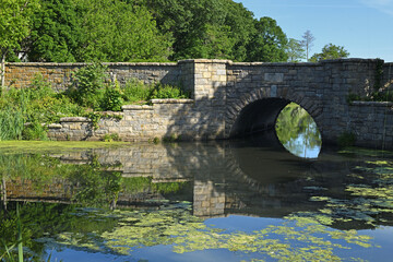 Fototapeta premium Picturesque landscape. Stone bridge of Frank Melville Park was built in 1936. Setauket, New York. USA