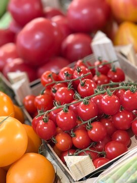Fresh cherry tomatoes on the vine at local farmers market close up