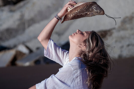 Woman enjoying freedom outdoors with straw hat