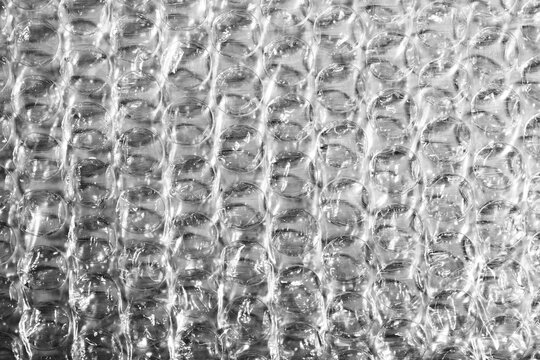 Monochrome macro shot of small-gauge bubble wrap against a black background