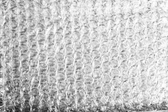 Monochrome macro shot of small-gauge bubble wrap against a black background