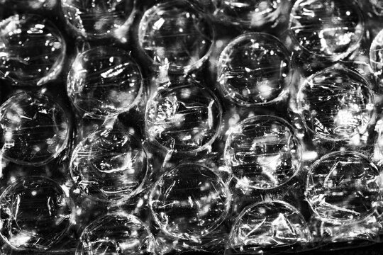 Monochrome macro shot of small-gauge bubble wrap against a black background