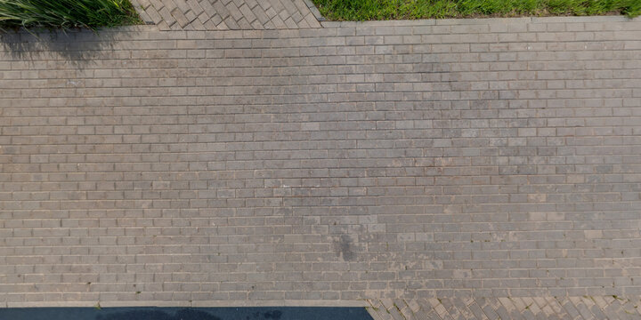 top view of surface of pedestrian path with paving slabs with the border of light and shadow