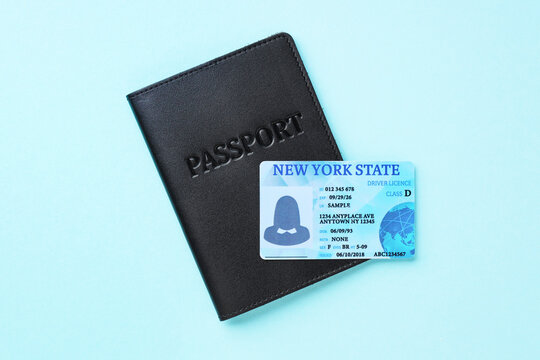 Driver's licence and passport on light blue background, top view