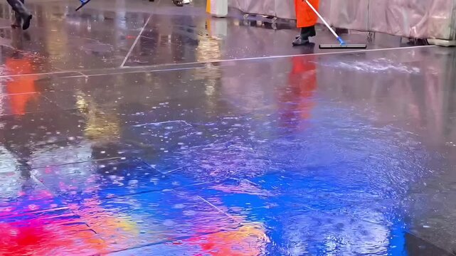 Janitors sweeping overfloow flood water with squeegee mop, Monsoon Storm Maintenance, Plumbing Problem, Cleanup Work, Rain Crisis Response