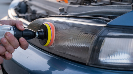 The process of polishing car headlights outdoors.  © Anna