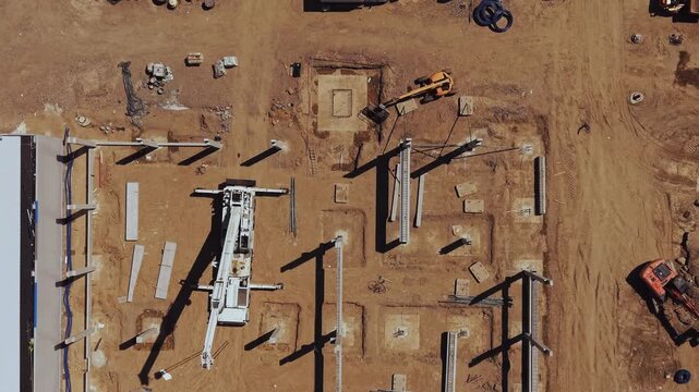 Top Down Drone Aerial Footage of a Shopping Mall Construction Site with Machinery and Buildings, Bird's Eye View