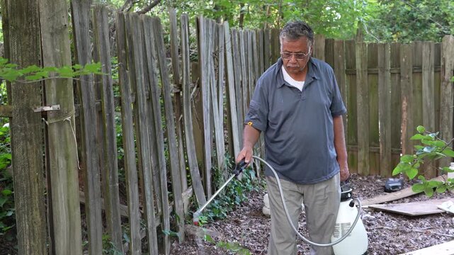 Slow motion clip of South Asian man spraying insecticide