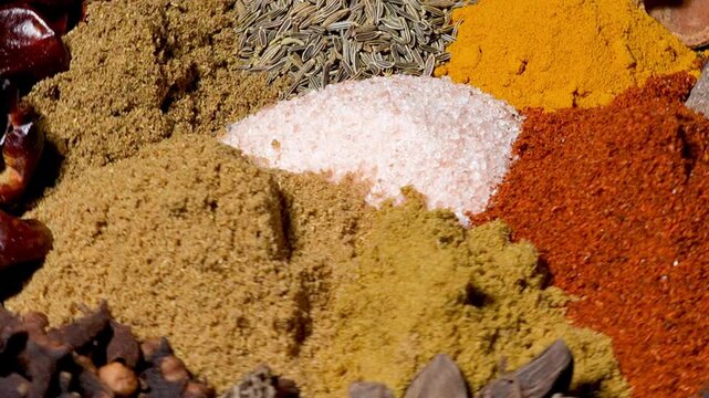 Macro shot of colorful Indian spices rotating, background texture