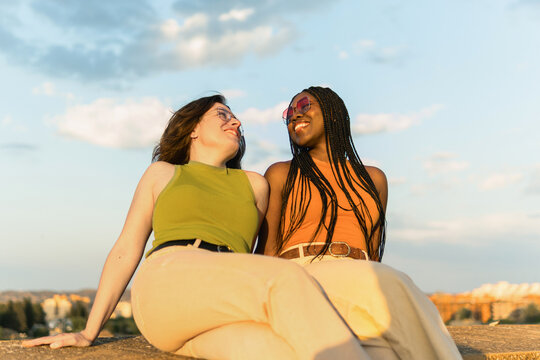 Diverse women laughing together enjoying golden hour