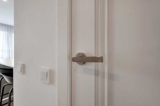 door handle on white wooden door in interior. Knob close-up elements. Door handle, fittings for interior design