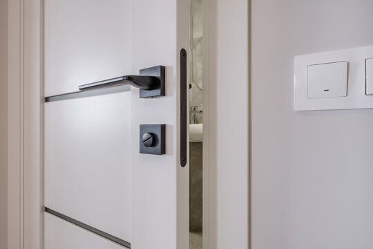 door handle on white wooden door in interior. Knob close-up elements. Door handle, fittings for interior design