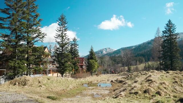 A tranquil mountain landscape featuring expansive open fields and rugged rocky terrain, captured from a wide-angle perspective. This scene is travel, nature, and landscape content.