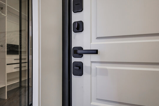 door handle on white wooden door in interior. Knob close-up elements. Door handle, fittings for interior design