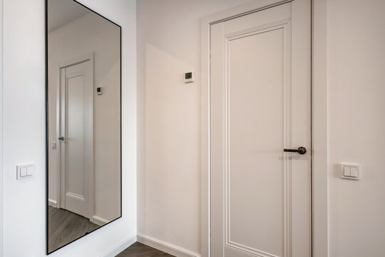door handle on white wooden door in interior. Knob close-up elements. Door handle, fittings for interior design