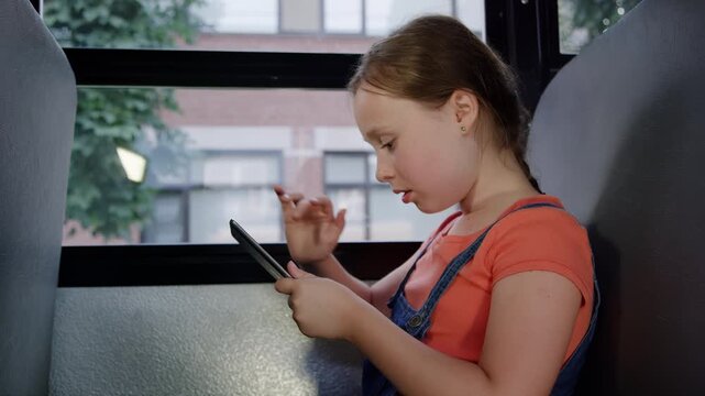 Girl on tablet calling friends after school on the bus