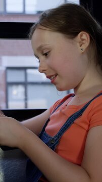 Tablet computer girl laughing on school bus