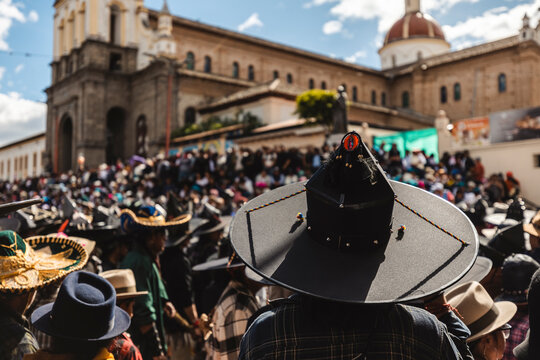 Indigenous dancers wearing traditional big black hats celebrating Inti Raymi festival in the main square of Cotacachi, Ecuador