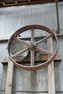 A large pulley wheel in an abandoned warehouse 
