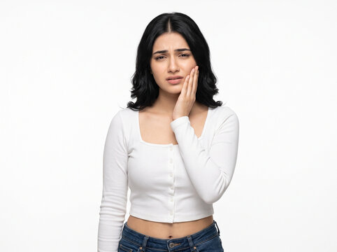 Beautiful young Indian woman holding her cheek with a painful toothache expression isolated on white background for dental care and healthcare advertising