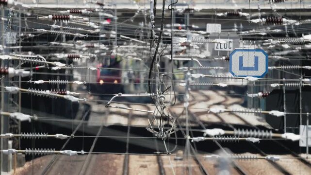 Complex overhead catenary system with train arriving at a station