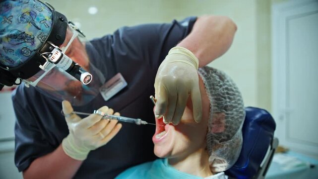 A dentist carefully administering local anesthetic with a syringe into a patient gum, preparing for a dental implant procedure