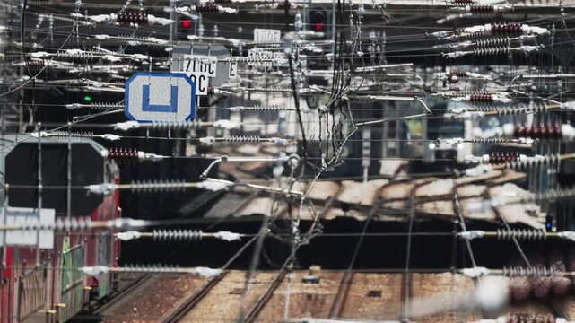Commuter train traveling on tracks through catenary wires