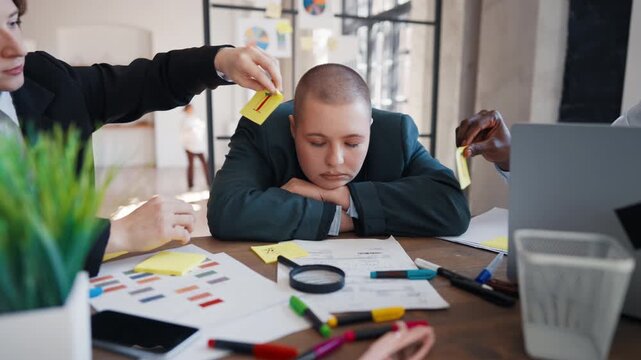 Funny moments in office, colleagues sticking notes on face of sleeping woman. Joke and humor, boring business meeting, young lady dozed off, coworkers kidding her, gluing fake drawn eyes, comedy