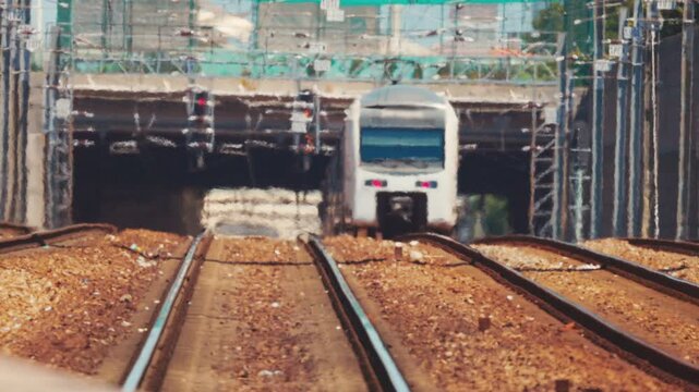 Commuter train exiting tunnel on railway tracks