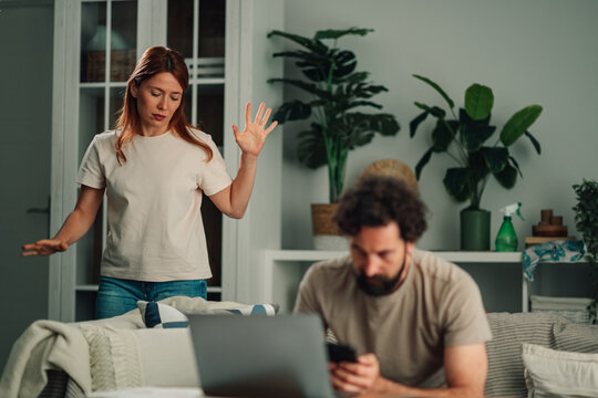 Woman arguing with husband ignoring her, experiencing relationship problems, conflict, and neglect at home