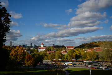 Obraz premium Panoramic View of Vilnius Old Town with Autumn Trees and Dramatic Clouds