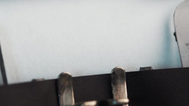 Text appears on paper from a typewriter showing the word START in a simple room setting during daylight hours